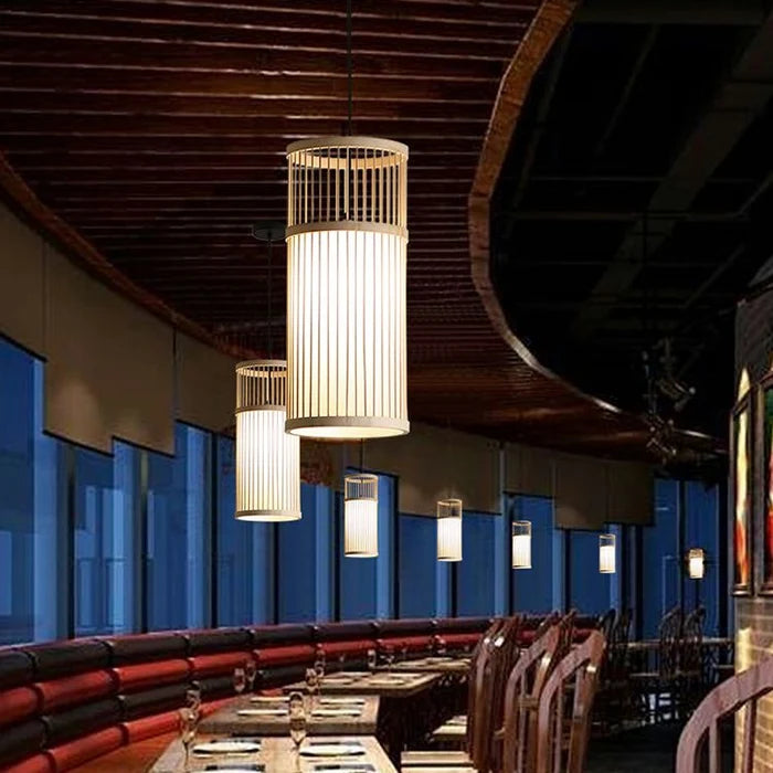 Tavera Suspension Cylindre en Bambou Tressé – cylindres dans une salle de restaurant aux fauteuils bleus