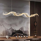 Onde Suspension LED Linéaire en Aluminium – ruban lumineux ondulé devant un mur aux motifs d'encre