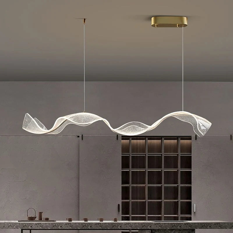 Onde Suspension LED Linéaire en Aluminium – ruban transparent ondulé au-dessus d'un meuble de rangement