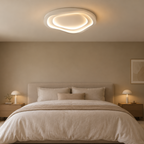 Récif Plafonnier LED Galet – dans une chambre beige avec lit