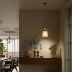 Calia Suspension Cloche en Verre, Douille Laiton – suspension ambrée dans un salon aux tons chauds avec plantes