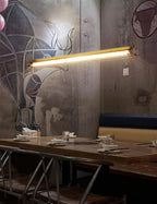 Tubia Suspension Tube en Verre Style Industriel – tube au-dessus d'une banquette bleue, mur en béton