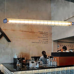 Tubia Suspension Tube en Verre Style Industriel – tube devant un mur en béton, vue d'atelier