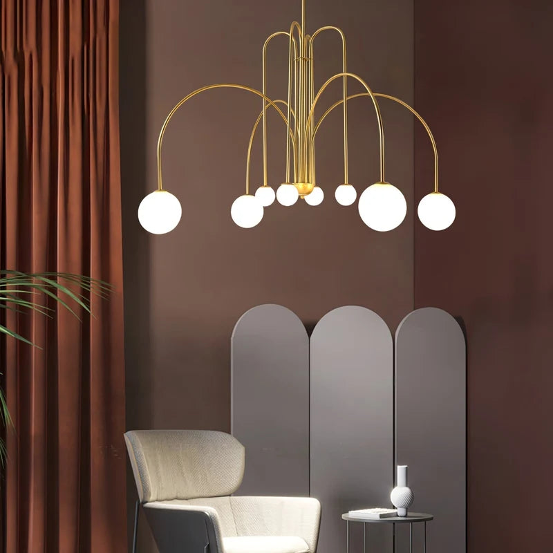 Arcadie Lustre à Bras en Arc – version dorée devant un rideau brun-rouge