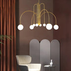 Arcadie Lustre à Bras en Arc – version dorée devant un rideau brun-rouge