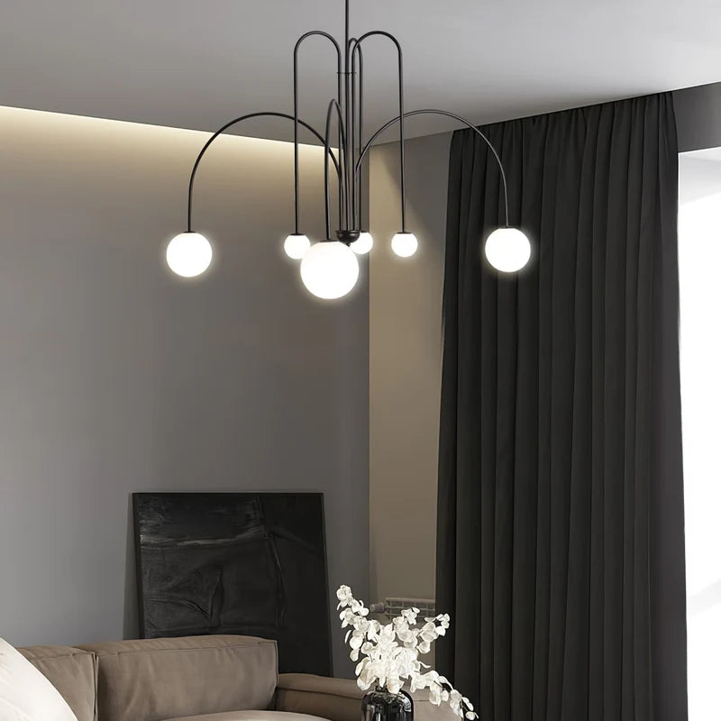 Arcadie Lustre à Bras en Arc – version noire devant un mur gris et un rideau sombre