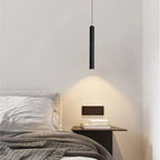 Filin Suspension Tube LED – au-dessus d'une table de chevet devant un mur blanc