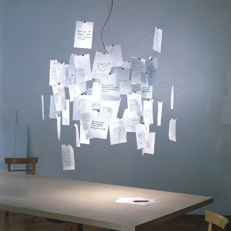 Carnet Suspension en Papier et Métal – cartes blanches allumées devant un mur gris