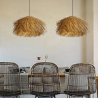Herbela Suspension Nid en Herbe Tressée ou Rotin – deux suspensions au-dessus d'une table et de chaises en rotin