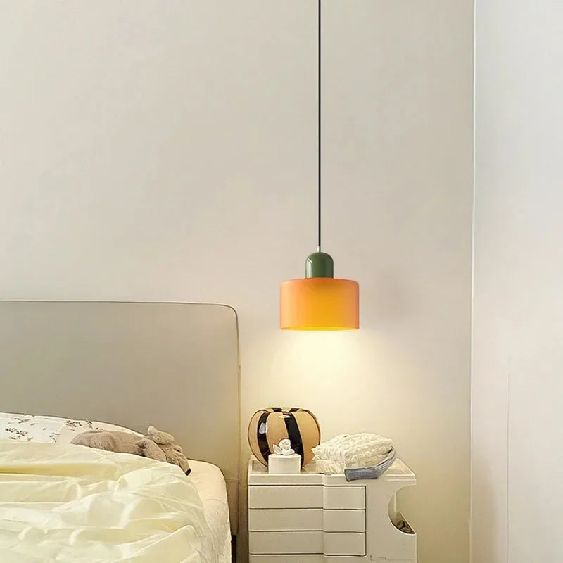 Dolia Suspension en Verre Teinté – petite suspension orange à côté d'un lit