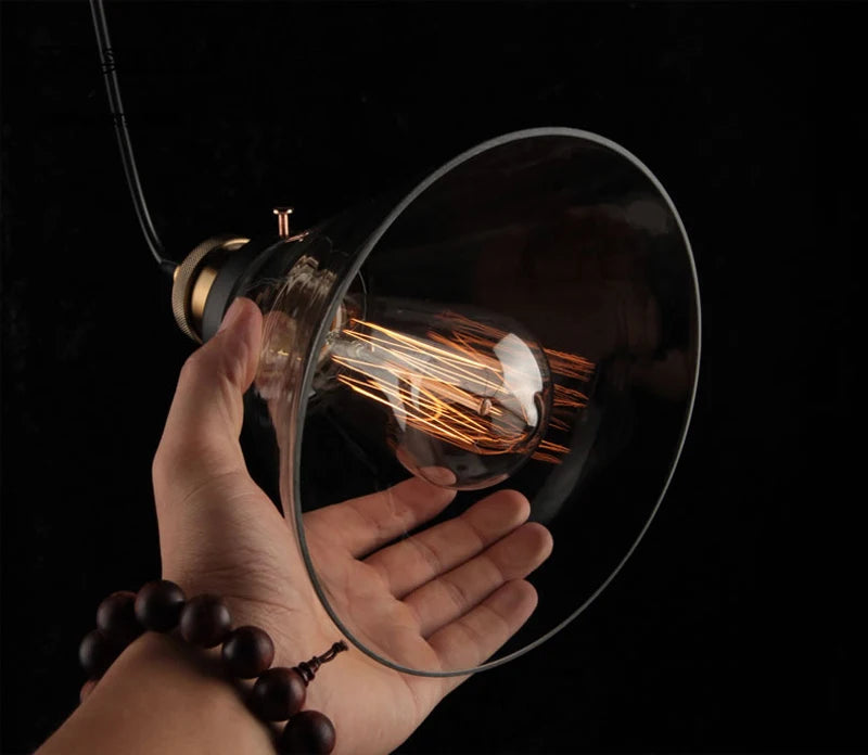 Platine de Plafond 3 Sorties, Ronde ou Linéaire – mains installant une ampoule à filament dans un abat-jour