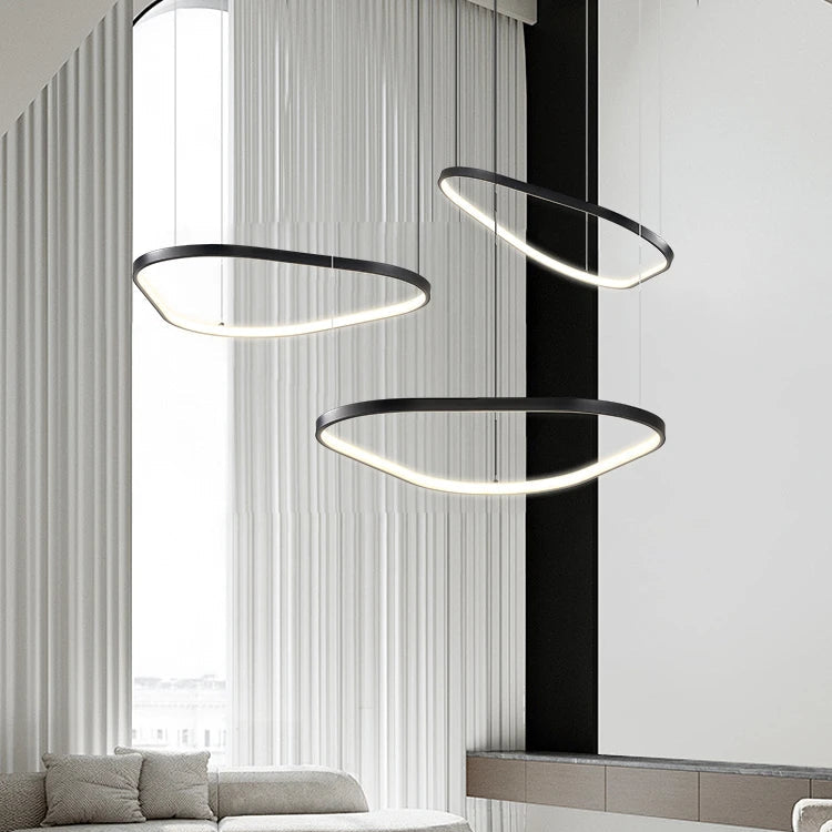 Orbite Trio Lustre 3 Anneaux LED Moderne – trois anneaux suspendus devant un mur à lattes