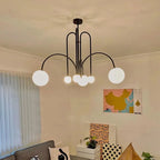 Arcadie Lustre à Bras en Arc – version noire près d'un tableau coloré
