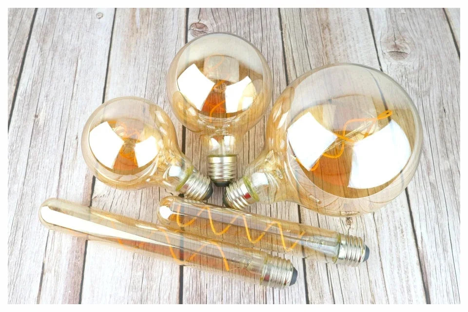 Ampoule Globe à Filament – ampoules globes et tube à filament posées sur une table en bois clair