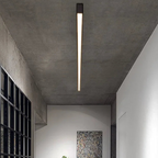 Rayon Plafonnier LED Linéaire – ligne lumineuse fine sur un plafond en béton près d'une verrière noire