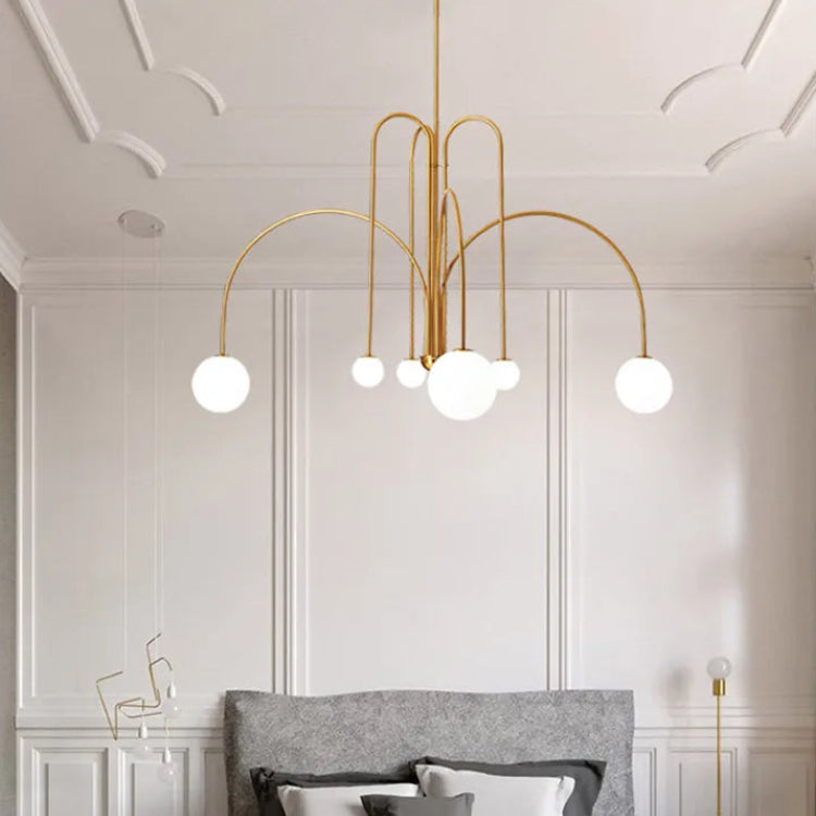 Arcadie Lustre à Bras en Arc – version dorée devant un mur blanc