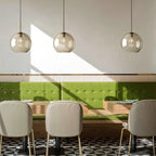 Ambra Suspension en Verre Ambré, 5 Formes au Choix – suspensions au-dessus d'une banquette verte de restaurant