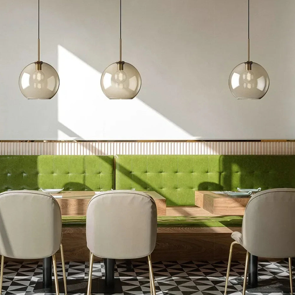 Ambra Suspension en Verre Ambré, 5 Formes au Choix – suspensions au-dessus d'une banquette verte de restaurant