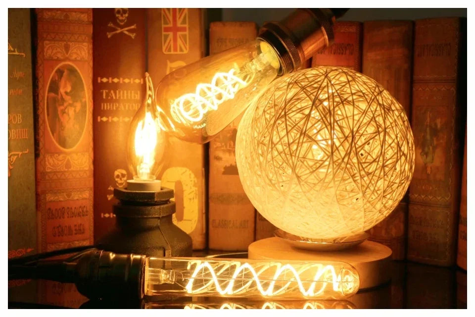 Ampoule Globe à Filament – globe à filament allumé près d'une boule tressée, décor sombre