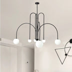 Arcadie Lustre à Bras en Arc – version noire dans une pièce claire avec lampe