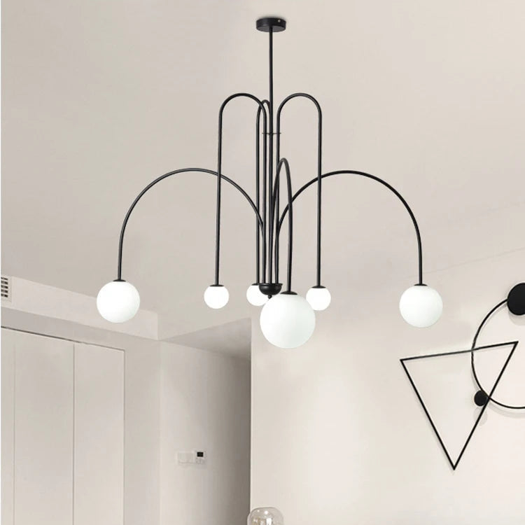 Arcadie Lustre à Bras en Arc – version noire dans une pièce claire avec lampe