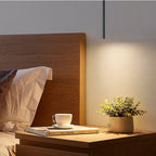 Filin Suspension Tube LED – près d'une tête de lit en bois et d'une plante