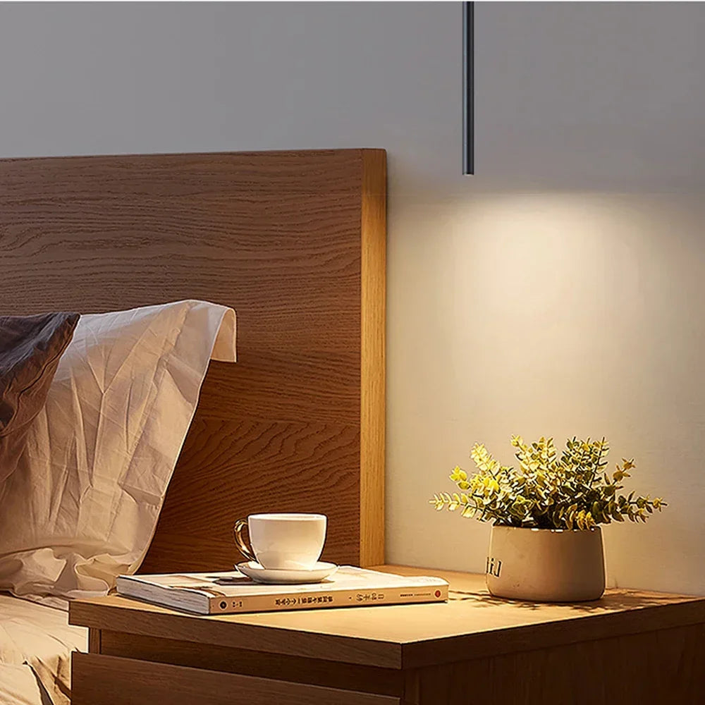 Filin Suspension Tube LED – près d'une tête de lit en bois et d'une plante