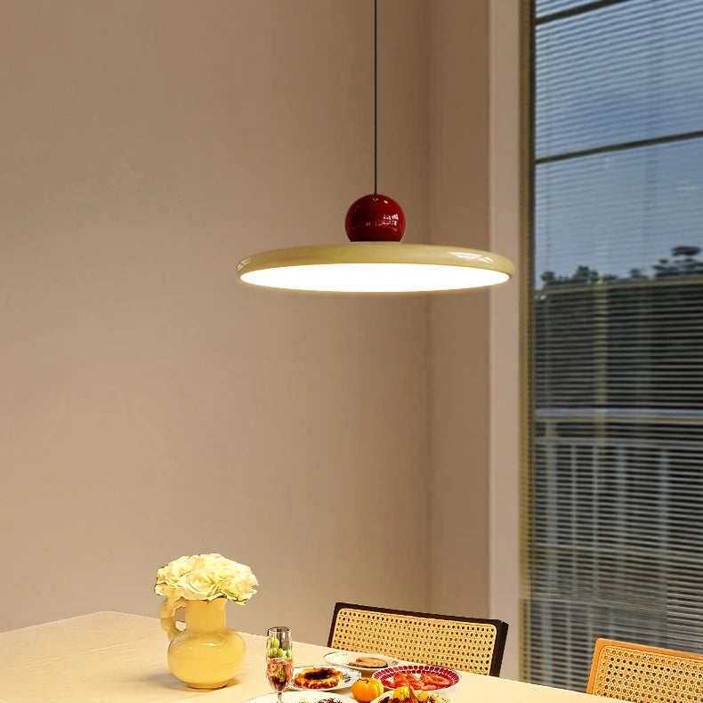 Papillon Suspension LED en Métal, Beige, Vert ou Rouge – disque beige à boule rouge devant une fenêtre