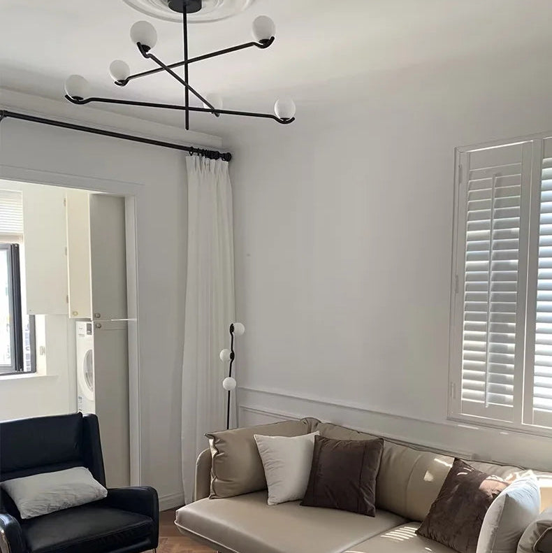 Perla Lustre à Globes en Verre – installé dans un salon lumineux avec rideau
