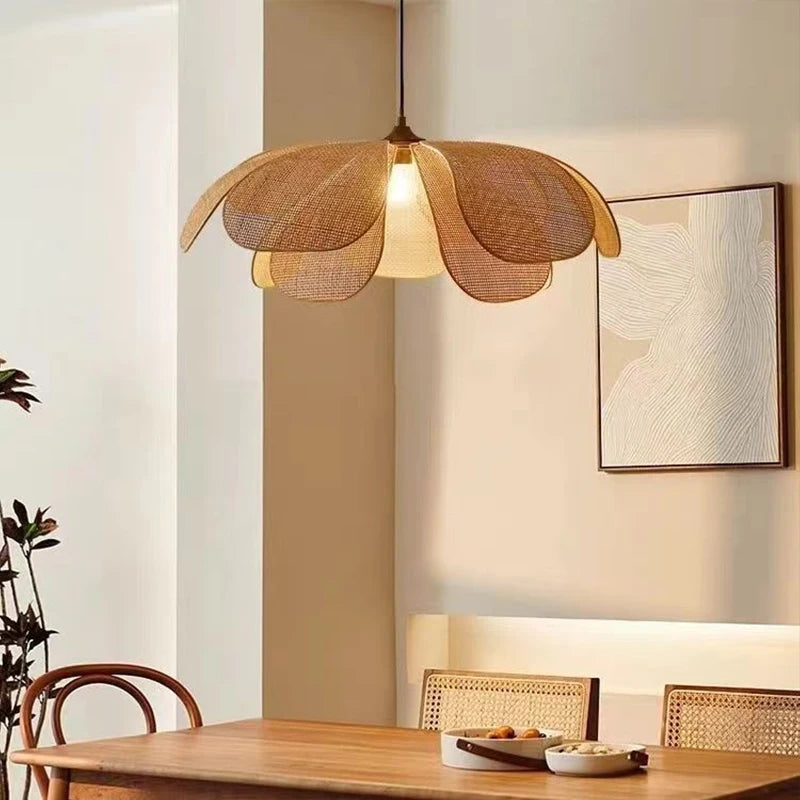 Lotus Suspension en Rotin Tressé – abat-jour près d'un mur blanc et d'un tableau