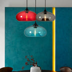 Irisa Suspension Globe en Verre Soufflé, 9 Teintes – suspensions rouge, turquoise et ambrée devant un mur bleu-vert