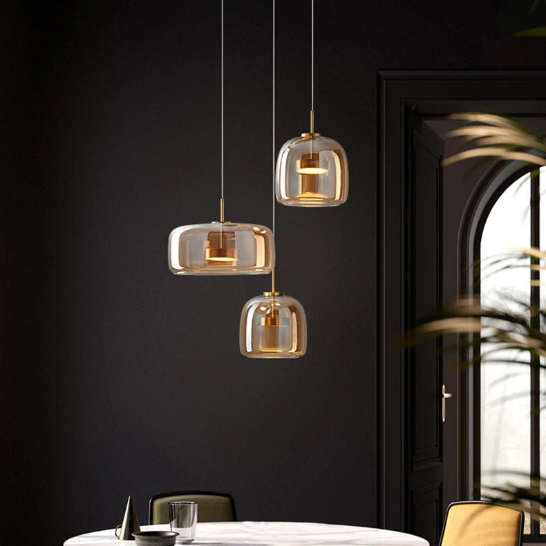 Trilia Suspension Trio en Verre, Ambré ou Fumé, sur Platine Ronde – suspensions en verre ambré devant une porte sombre