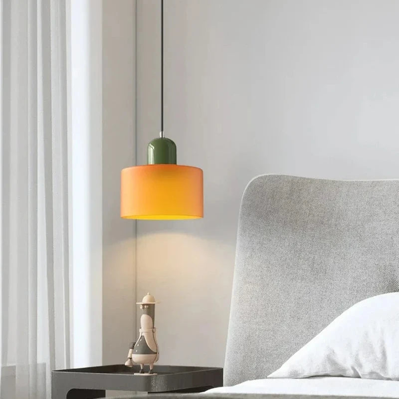 Dolia Suspension en Verre Teinté – suspension orange à capuchon vert devant un fauteuil gris