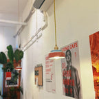 Hexa Suspension en Céramique – suspension terracotta devant des affiches colorées