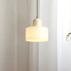 Dolia Suspension en Verre Teinté – suspension en verre blanc crème allumée près d'une plante