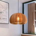 Citrelle Suspension Citrouille en Bambou Tressé – abat-jour allumé devant un décor mural