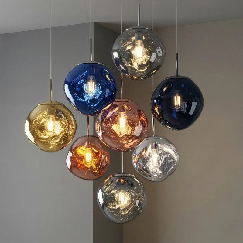Lavane Suspension Globe en Verre Fondu Irrégulier – globes bleus, dorés et orange devant un mur gris
