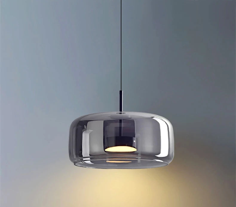 Ambrine Suspension en Verre Fumé ou Ambré, 1 Tête – suspension en verre fumé allumée devant un mur bleu-gris