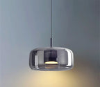 Ambrine Suspension en Verre Fumé ou Ambré, 1 Tête – suspension en verre fumé allumée devant un mur bleu-gris