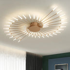 Éclat Plafonnier LED Étoilé – bras dorés allumés sur un plafond beige