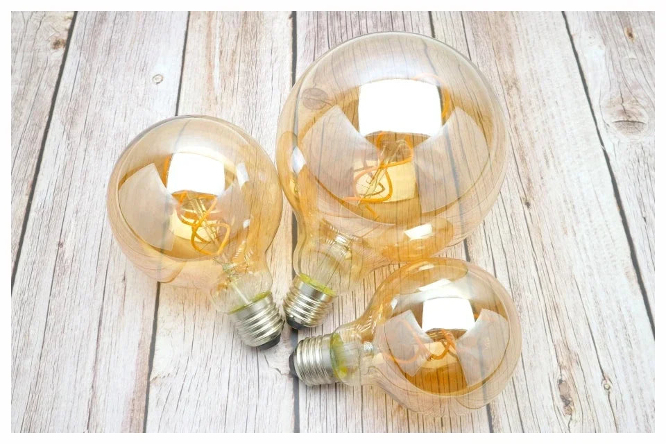 Ampoule Globe à Filament – ampoules globes à filament posées sur une table en bois clair