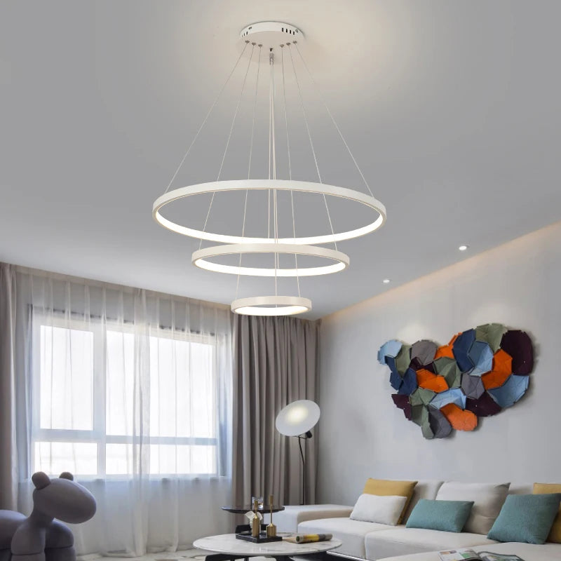 Orbite Suspension LED à Anneaux – anneaux blancs devant des voilages et une œuvre colorée