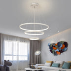 Orbite Suspension LED à Anneaux – anneaux blancs devant des voilages et une œuvre colorée