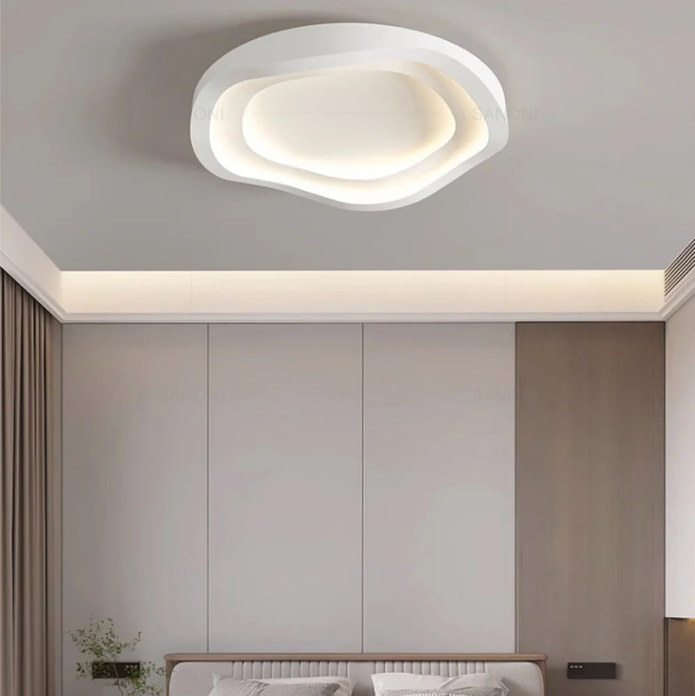 Récif Plafonnier LED Galet – dans une pièce aux placards gris et corniche lumineuse