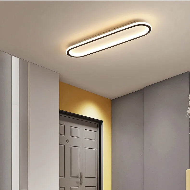 Piste Plafonnier LED Oblong – dans une entrée avec porte grise et mur jaune