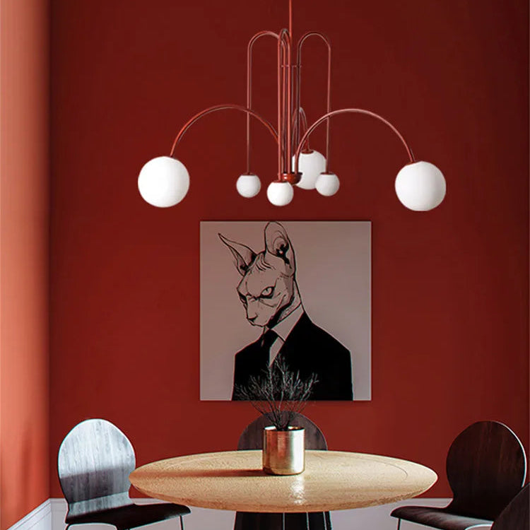 Arcadie Lustre à Bras en Arc – version bordeaux devant un mur rouge et une illustration