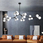 Ramure Lustre Branches à Globes Lumineux – globes blancs dans un salon bleu-gris avec tableau