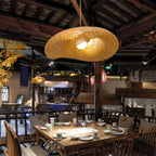 Savane Suspension Soucoupe en Rotin Tressé – abat-jours dans un restaurant aux tons sombres