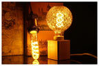 Ampoule à Filament Spirale – globe à filament allumé près d'une boule tressée, ambiance chaude