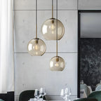Ambra Suspension en Verre Ambré, 5 Formes au Choix – suspensions devant un mur en marbre sombre